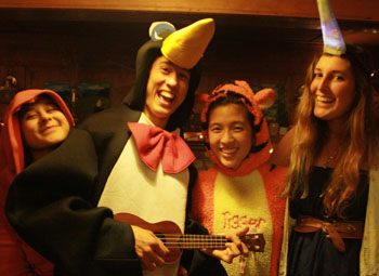  Coopers wearing funny costumes laughing, smiling, one is playing a ukulele.